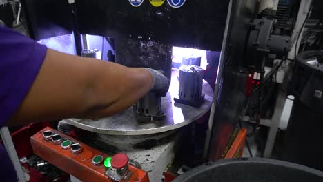 worker in a factory operating a production line machine