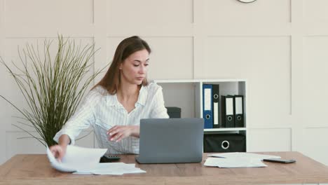 mujer trabajando con papeles en su escritorio
