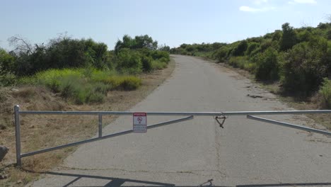 aerial footage of a closed road enveloped by an overgrown, unmaintained rural landscape