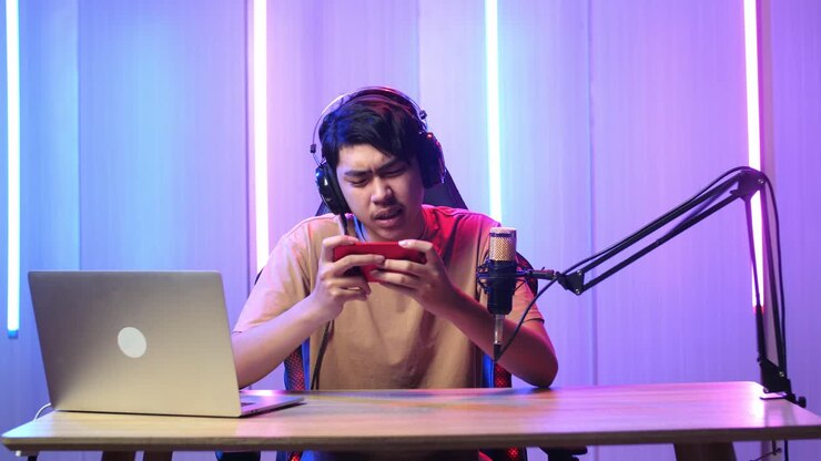 Uomo asiatico che gioca a un videogioco con il telefono cellulare, poi perde la partita durante una diretta streaming.