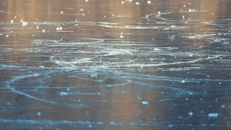 cracks and shards scatter across the surface of a frozen pond, reflecting light and creating a beautiful pattern