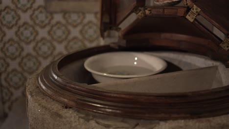 baptismal font with a white bowl inside a stone basin, symbolizing the sacred ritual of baptism