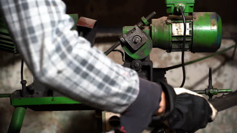 Encendiendo-La-Máquina-Afiladora-De-Sierra-De-Cinta,-El-Trabajador-Pone-La-Hoja-En