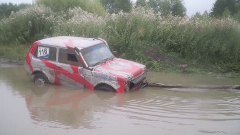 off-road vehicle stuck in a muddy puddle