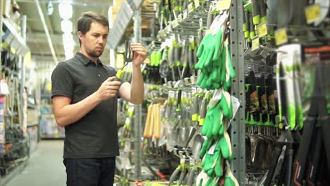 hombre comprando herramientas de jardín en una tienda de mejoras para el hogar