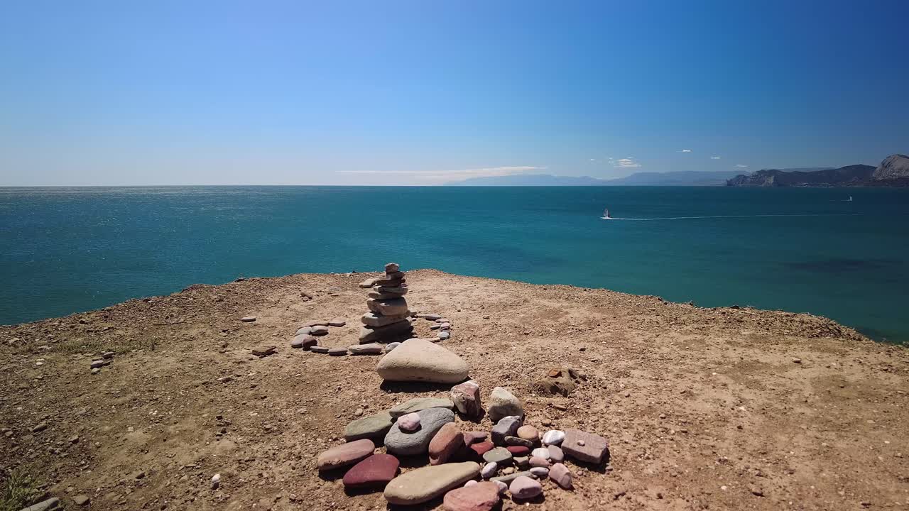 una pirámide de piedras contra el telón de fondo de las aguas verdes del mar negro y el horizonte azul