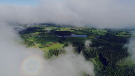 toma de drones de un hermoso paisaje rural verde a través de nubes blancas en un día soleado