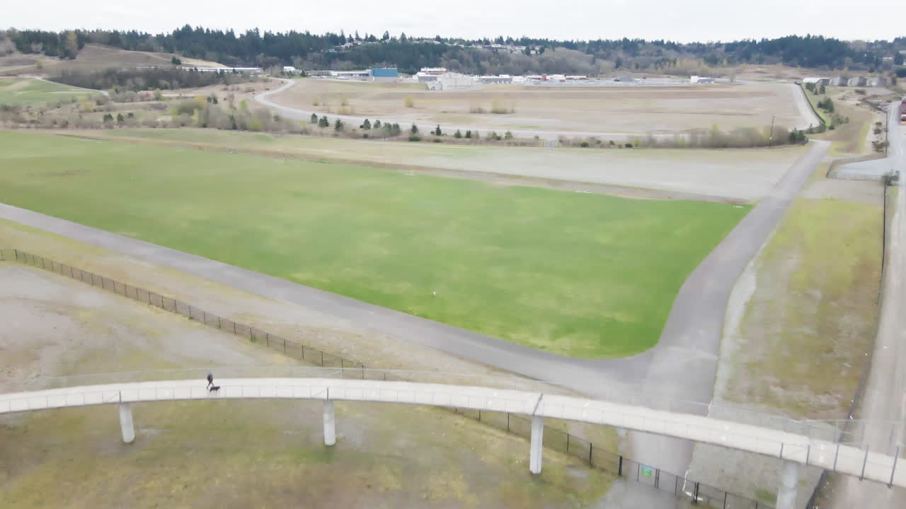 AERIAL DRONE SHOT OF TRAIN TRACKS UNDER A WALKING BRIDGE IN TACOMA WASHINGTON