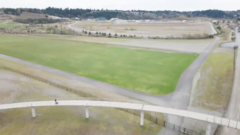 AERIAL-DRONE-SHOT-OF-TRAIN-TRACKS-UNDER-A-WALKING-BRIDGE-IN-TACOMA-WASHINGTON