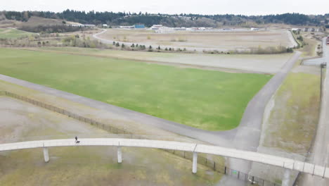 aerial drone shot of train tracks under a walking bridge in tacoma washington