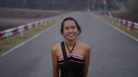 portrait of a smiling woman on a rural road