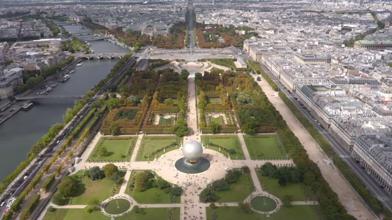 A breathtaking aerial drone view over Paris captures the Tuileries Garden, the Seine River, the Olympic Games cauldron ball and the historic city skyline stretching into the horizon