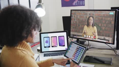 mujer de negocios afroamericana en videollamada con una colega caucásica en la pantalla
