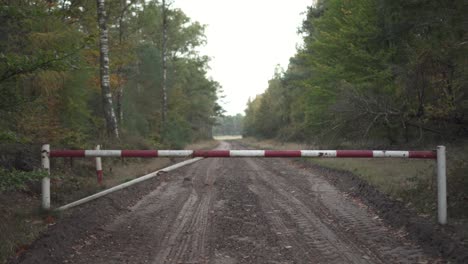 entrada cerrada al parque forestal con sendero áspero a principios de otoño