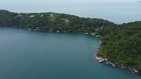 pan shot of secluded brazilian beach within tropical lush green forest on peninsula