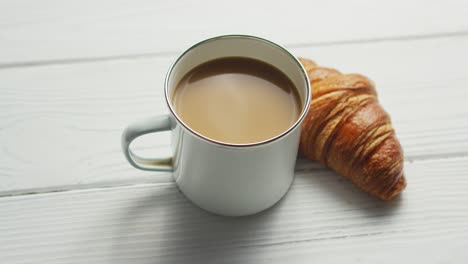 cup of coffee and baked croissant