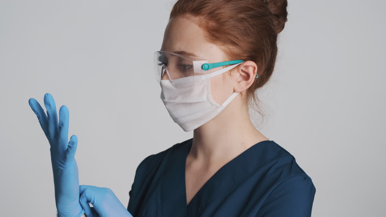 médico pelirrojo frente a la cámara sobre un fondo gris.