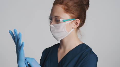 redheaded doctor in front of camera on gray background.