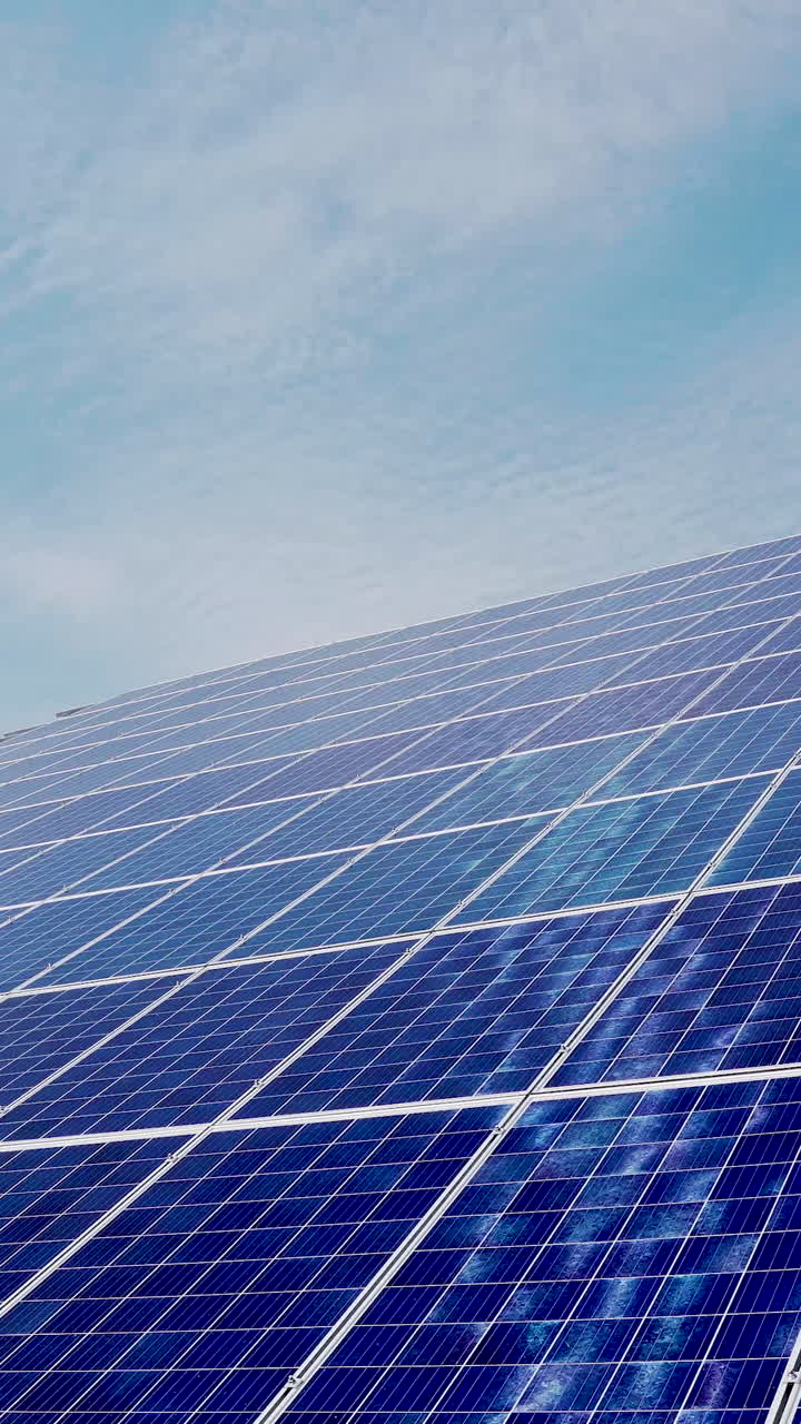 Modern photovoltaic solar battery wall. Energy solar panels installed on rooftop. Concept for ecology. Blue sky background. Vertical video