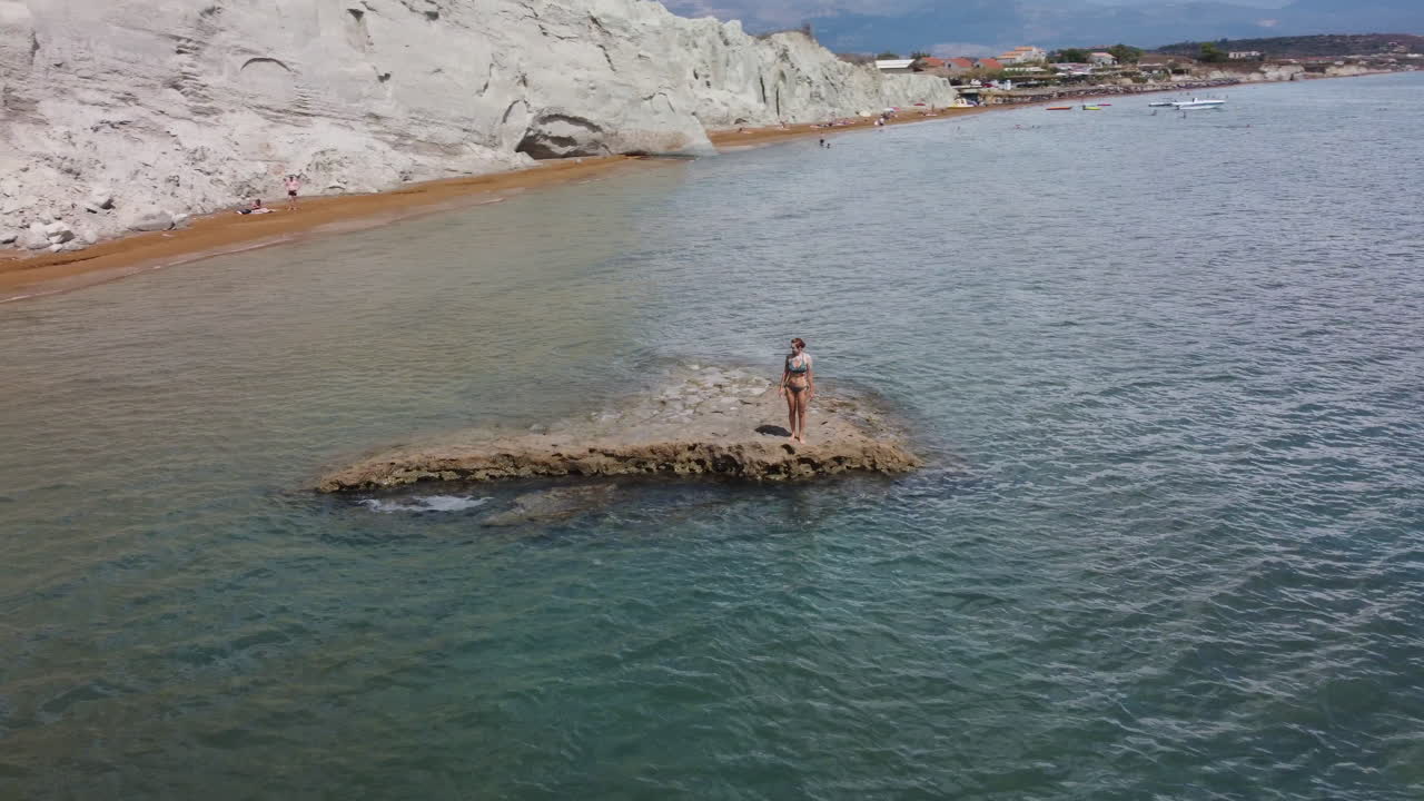 mujer camina por la costa de la playa de arcilla, cefalonia, cefalonia en grecia