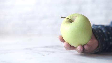 manzana verde en la mano de un niño