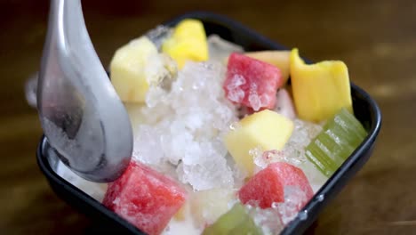 mixing fruits and ice in a bowl