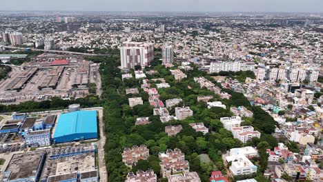profile drone view of residential buildings with trees surrounding them in chennai, india during daytime