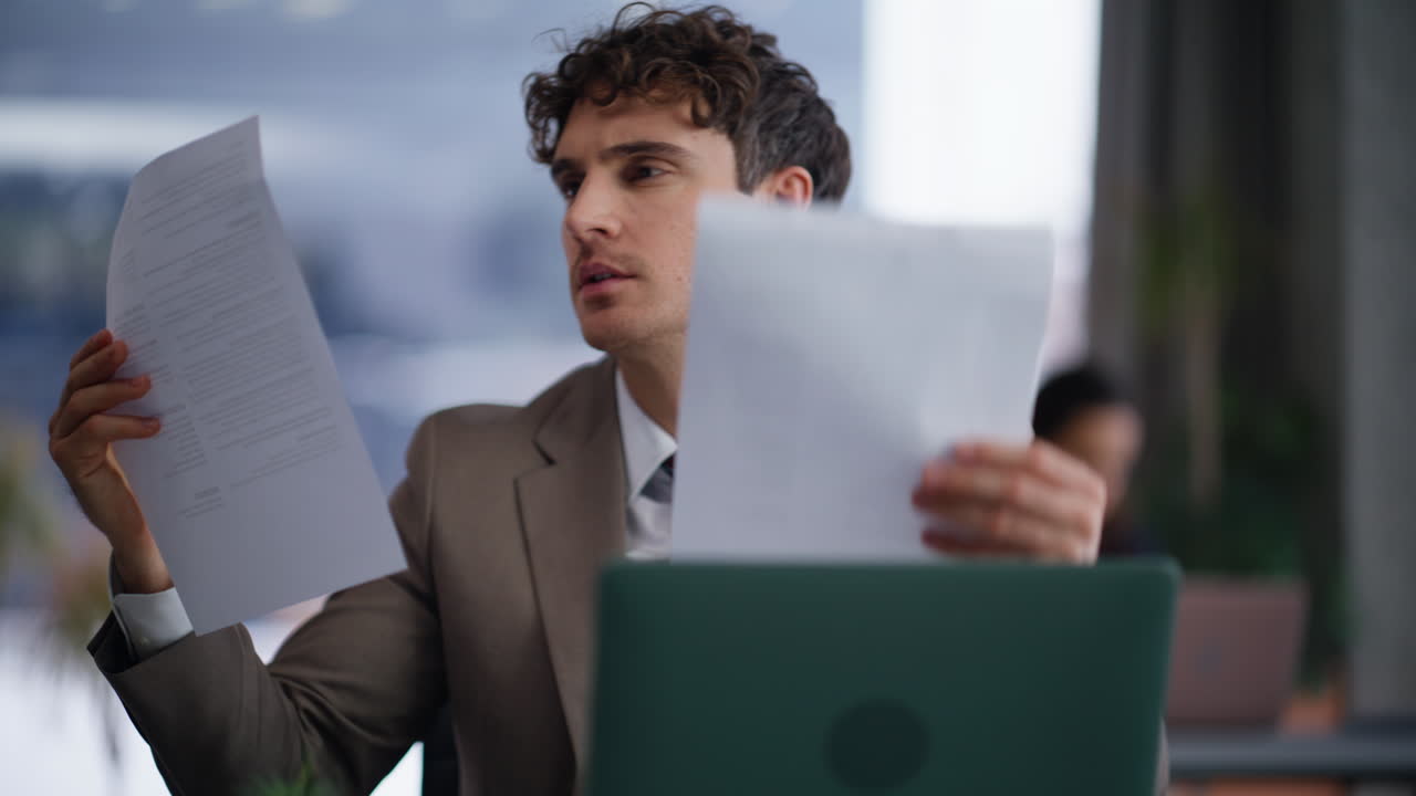 Frowning man reviewing papers modern workplace closeup. Happy manager at office