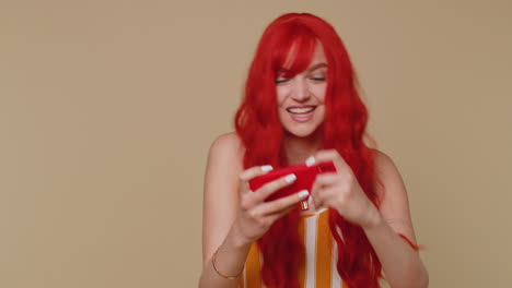 Worried-funny-addicted-redhead-girl-enthusiastically-playing-drive-racing-video-game-on-mobile-phone