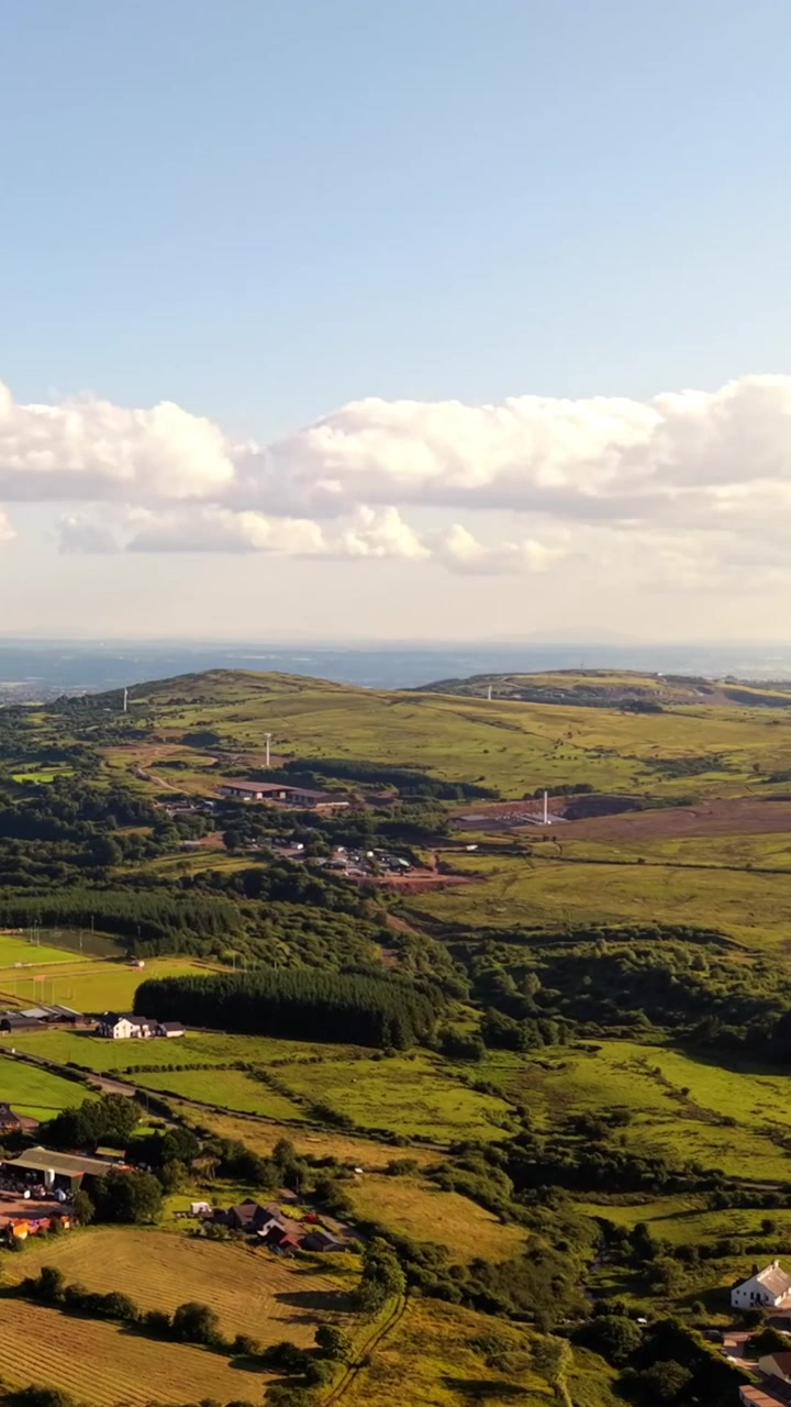 Dynamiczne wideo z lotu ptaka Czarnej Góry w Zachodnim Belfaście, Irlandia Północna, w jasny letni wieczór. Wyprodukowano w 60 klatkach na sekundę, proporcjach społecznościowych 1080x1920 i z kolorem Rec709
