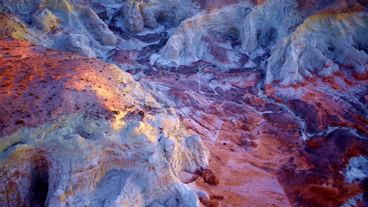 A slow-moving drone shot showcases the dramatic terrain of painted hills and unique hoodoos near the Utah-Arizona border.
