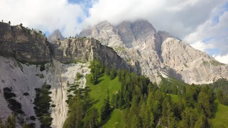 Volar-Sobre-La-Montaña-Verde-Con-Un-Bosque-De-Pinos-En-Un-Acantilado-Y-Picos-Montañosos,-Parque-Nacional-Tre-Cime,-Belluno,-Italia