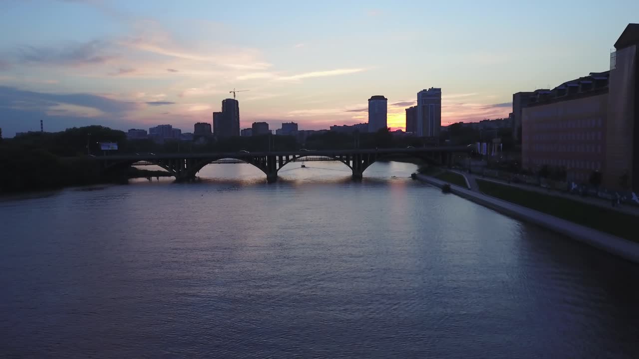 Atardecer en la ciudad sobre el río con puente