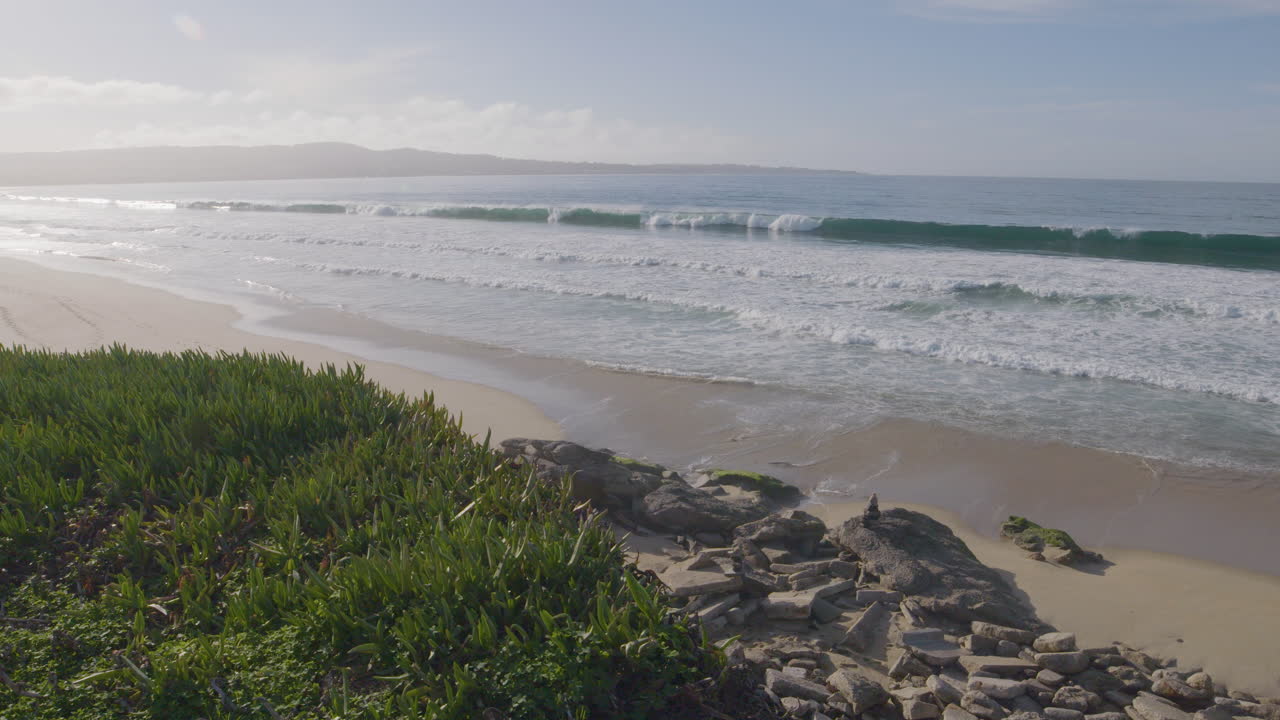 toma en cámara lenta de olas en un día soleado con cielos azules en marina state beach monterey bay california