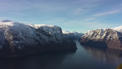 sorvolando la persona che cammina verso la punta del punto di osservazione di stegastein sopra aurlandsfjord - punto di vista aereo in movimento in avanti e volo nel vasto paesaggio montano sopra il fiordo - norvegia