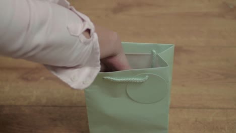 mujer mirando dentro de una bolsa de regalo