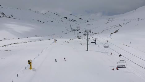 People skiing next to chairlift in Alto Campoo ski resort aerial shot