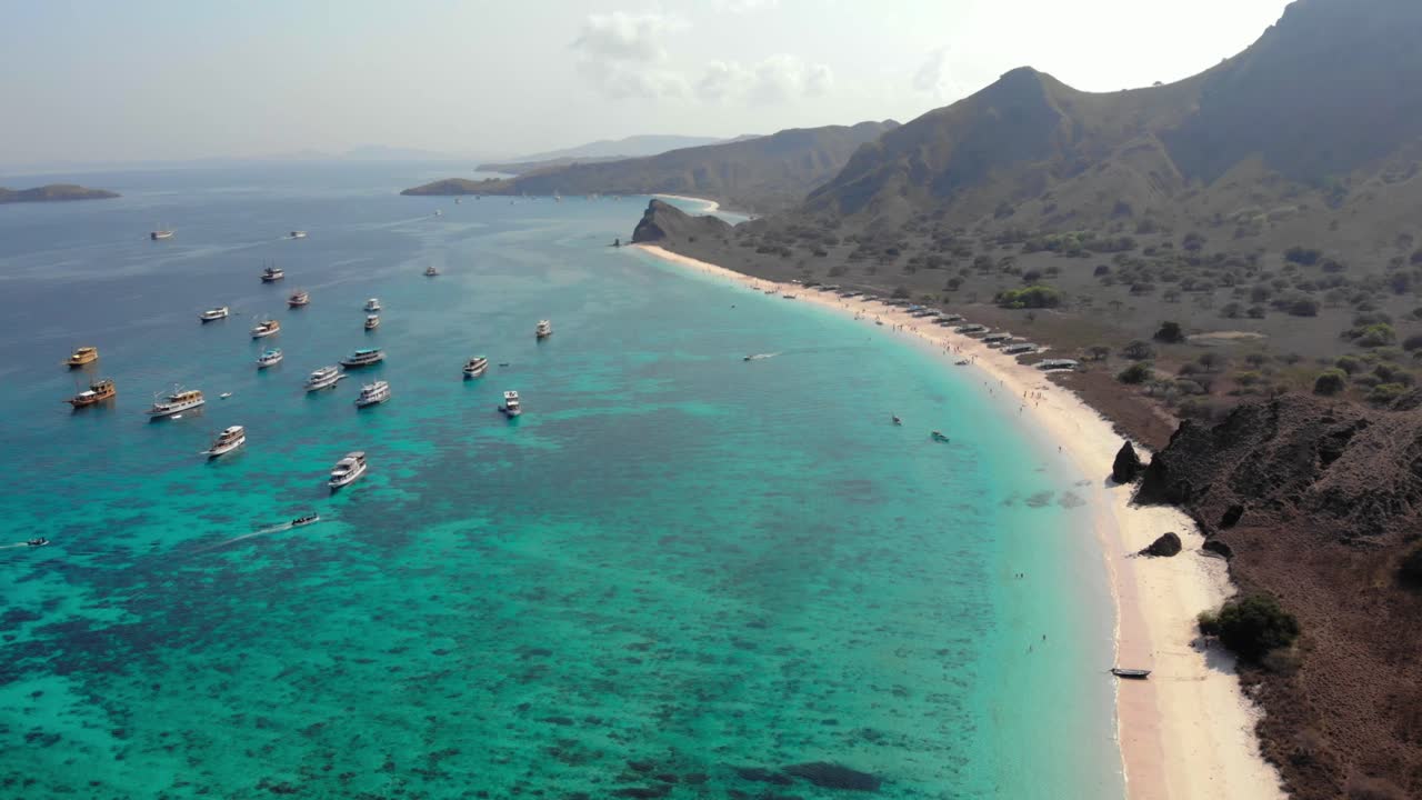 Vista panoramica della Spiaggia Rosa con colline aspre e acqua turchese sull'isola di Padar nel Parco Nazionale di Komodo, Indonesia.