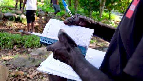 hombre trabajando afuera con un talonario de recibos en bougainville, papua nueva guinea
