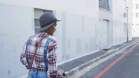 Mixed-race-woman-using-electric-scooter