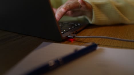 person using a laptop and charging it