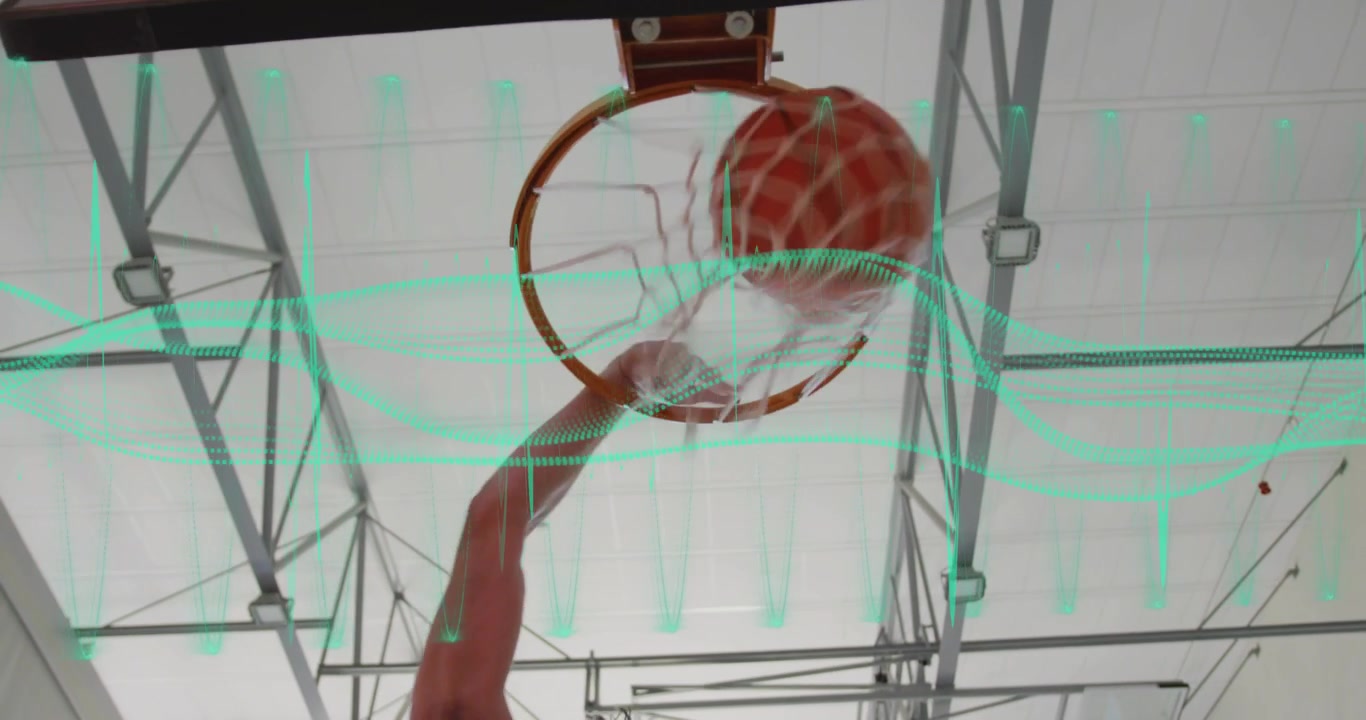 Braccio di un giocatore che entra nell'inquadratura e tira la palla nel canestro durante un allenamento sportivo per segnare, facendo ondeggiare la retina.