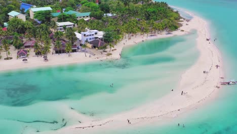 Aerial-flyover-above-beach-resort-on-shore-of-calm-lagoon-in-the-Philippines