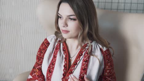 portrait of a pretty girl in an embroidered authentic ukrainian shirt thoughtfully adjusts her hair