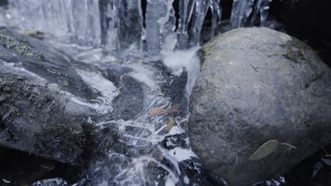 Wide-and-close-tilt-shot-of-a-little-frozen-waterfall