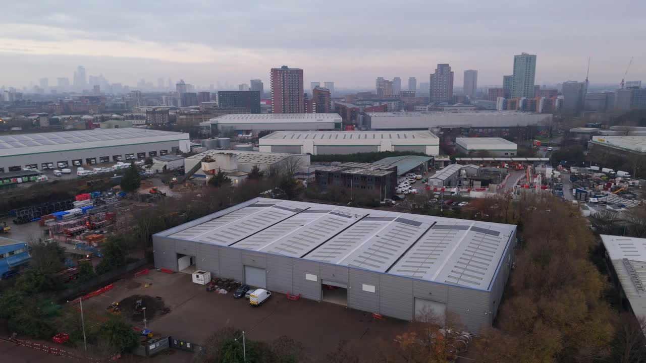 Panoramica aerea di magazzini industriali nel quartiere londinese di Docklands con skyline della città