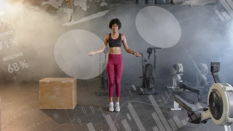 Animation-of-data-on-interface-over-african-american-woman-jumping-rope,-cross-training-at-gym