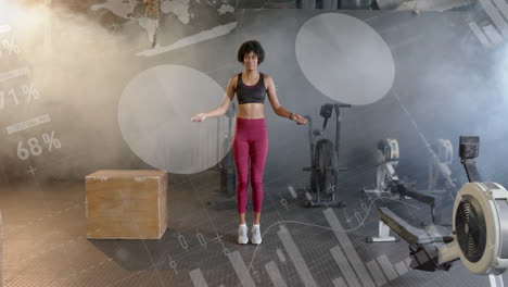 animación de datos en la interfaz sobre mujer afroamericana saltando la cuerda, entrenamiento cruzado en el gimnasio
