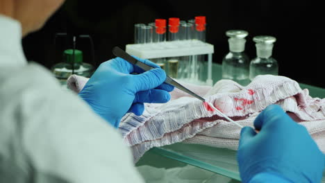 crime lab worker examines evidence on clothes 4