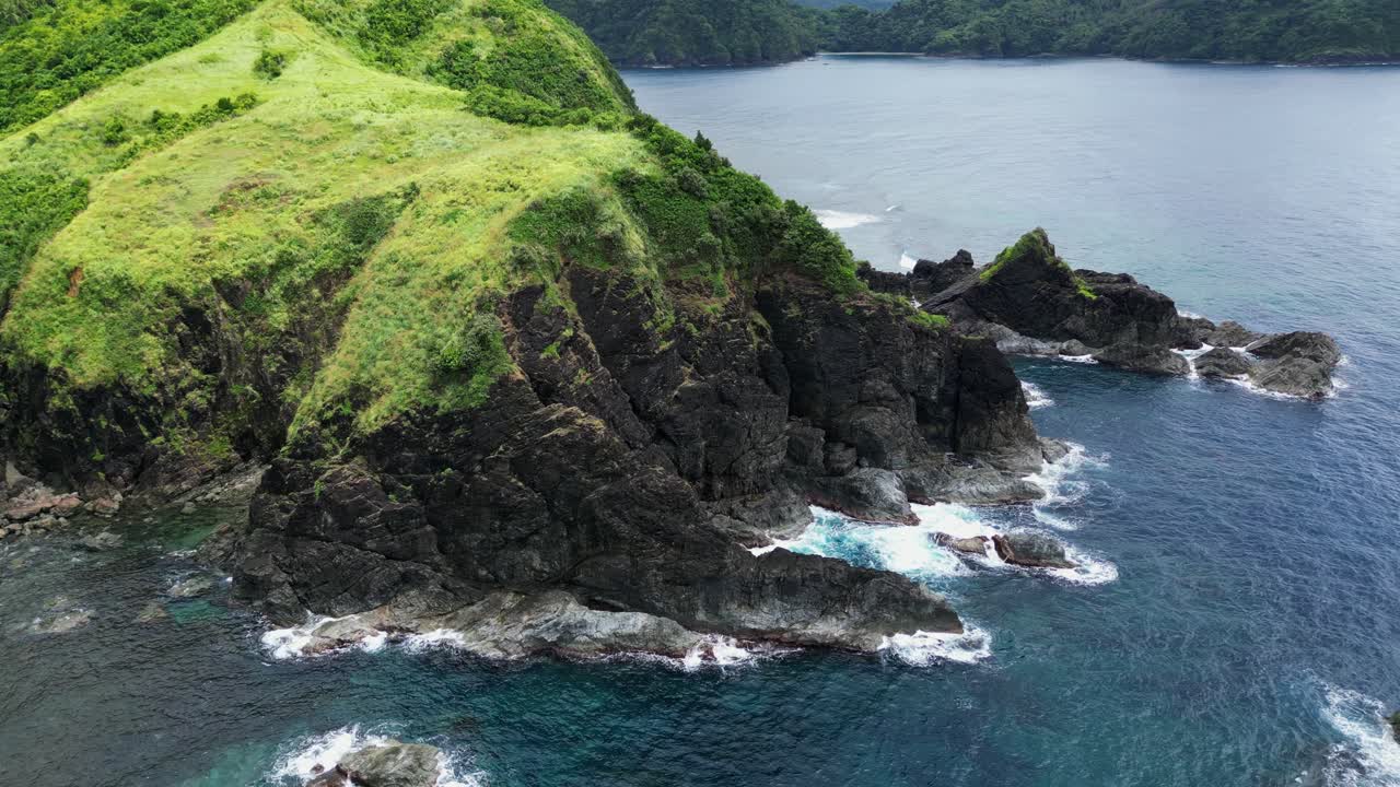 Rolling green basalt cliff covered in grass at oceans edge, baras catanduanes